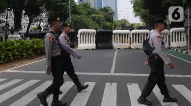 Aparat kepolisian melintas di jalan Imam Bonjol depan Gedung Komisi Pemilihan Umum (KPU) Republik Indonesia, Senin (11/13/2023). (merdeka.com/Imam Buhori)