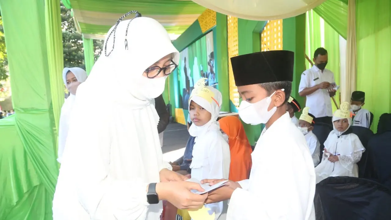 Bupati Banyuwangi Ipuk Fiestiandani memberikan santunan terhadap anak yatim dalam acara festival Muharram dengan cara non tunai. (Istimewa)