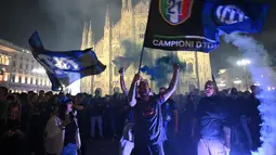 Kemenangan atas Parma pada laga pekan ke-35 ini memastikan perolehan poin Nerazzurri tidak lagi terkejar oleh pesaing terdekatnya, Napoli. Tampak dalam foto, para pendukung Inter Milan merayakan gelar juara Serie A musim 2025/2026 atau scudetto ke-21 di Piazza Duomo, Milan, Italia, Minggu (3/4/2026) malam waktu setempat atau Senin (4/5/2026) dini hari WIB. (PIERO CRUCIATTI/AFP)