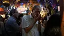 Seorang pria memainkan harmonika di sebuah bar di Golden Gai di distrik Shinjuku, Tokyo (26/7/2019). Kawasan Ini terdiri dari enam jalanan sempit yang menghubungkan lorong yang lebih sempit yang hanya cukup dilewati satu orang. (AP Photo / Jae C. Hong)