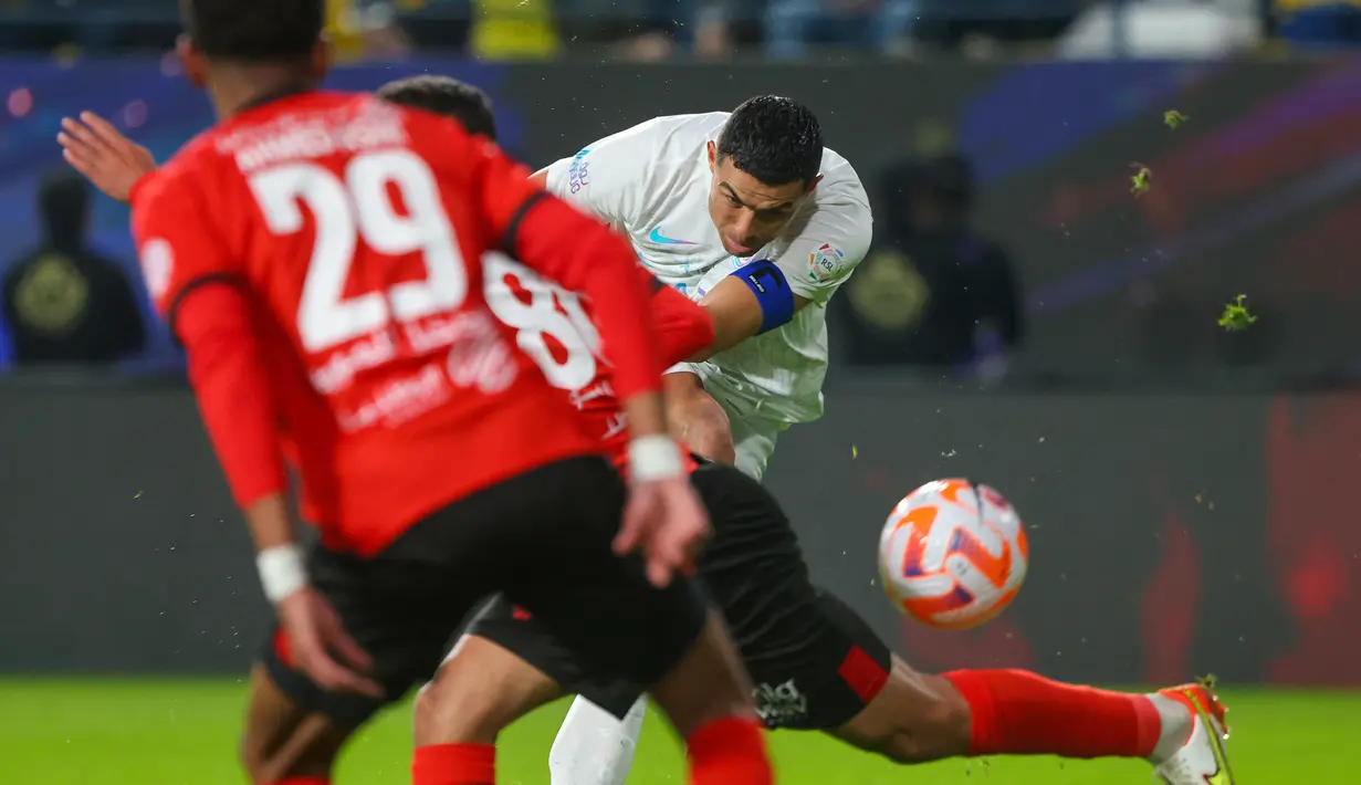 Pemain Al Nassr, Cristiano Ronaldo (kanan), menendang bola ke gawang Al Riyadh dalam laga pekan ke-16 Saudi Pro League 2023/2024 yang digelar di Al Awwal Park, Sabtu (9/12/2023) dini hari WIB. Cristiano Ronaldo saat ini memimpin perebutan gelar top skor Saudi Pro League 2023/2024 dengan catatan 16 gol. (AFP/Fayez Nureldine)