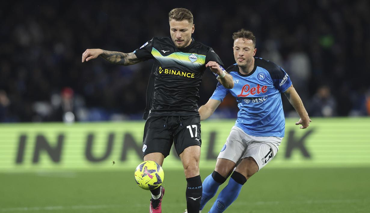 Penyerang Lazio Ciro Immobile berebut bola dengan bek Napoli Amir Rrahmani pada giornata ke-25 Liga Italia di Stadion Diego Armando Maradona, Sabtu (4/3/2023) dini hari WIB. Meski kalah, posisi Napoli masih aman di puncak klasemen Liga Italia dengan 65 poin dari 25 pertandingan. (Alessandro Garofalo/LaPresse via AP)