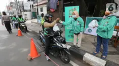 Ojek online (ojol) menerima bantuan berupa bingkisan makan siang dan hand sanitizer di kawasan Jalan Raden Saleh, Jakarta, Selasa (7/3/2020). Bantuan dari DPP PKB guna meringankan beban ojol yang sepi orderan akibat lesunya perekonomian selama pandemi corona Covid-19. (Liputan6.com/Fery Pradolo)