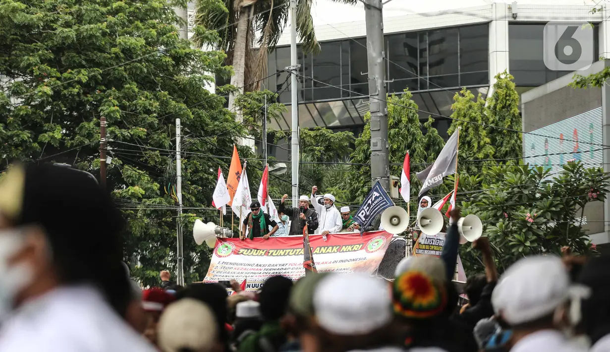Massa aksi menolak omnibus law saat unjuk rasa di area sekitar Patung Kuda, Jakarta Pusat, Selasa (13/10/2020). Massa mulai berdatangan sejak pukul 11.10 WIB.  Kedatangan massa seiring dengan mobil komando aksi yang juga tiba di lokasi. (Liputan6.com/Faizal Fanani)