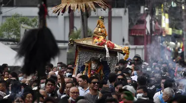 Orang-orang mengambil bagian dalam prosesi ketika para imam membawa Seto Machindranath, dewa pelindung Nepal, selama festival kereta di Kathmandu (9/4/2022). (AFP/Prakash Mathema)