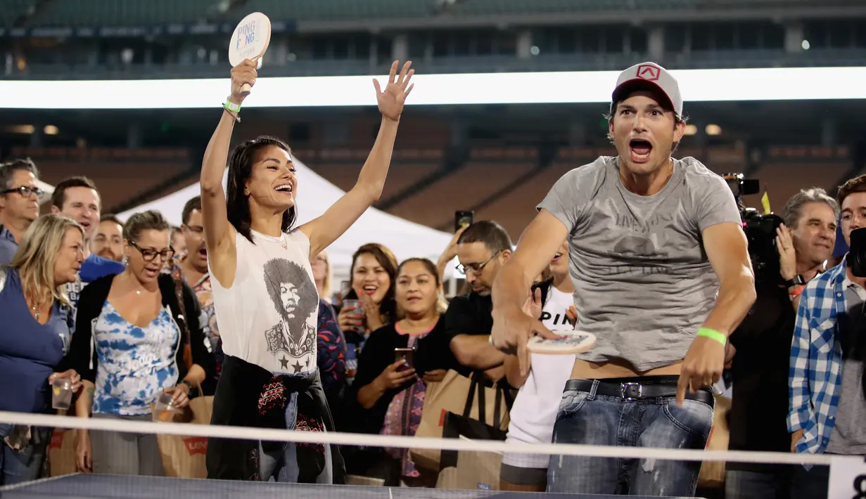 Ekspresi pasangan selebriti, Mila Kunis (kiri) dan Ashton Kutcher (kanan) saat bermain pingpong di acara tahunan ke-6 dari Clayton Kershaw, Ping Pong 4 Purpose, Los Angeles, Amerika Serikat, Kamis (23/8). (CHRISTOPHER POLK/GETTY IMAGES NORTH AMERICA/AFP)
