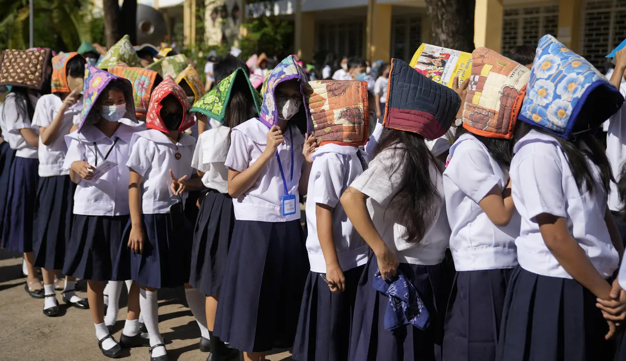 <p>Siswa mengenakan pelindung di kepala mereka untuk perlindungan selama latihan gempa di sebuah sekolah dasar di Metro Manila, Filipina, Kamis (8/9/2022). Filipina melakukan latihan gempa nasional kuartal ketiga sebagai bagian dari upaya untuk membuat publik mengetahui protokol dan tanggapan selama bencana. (AP Photo/Aaron Favila)</p>