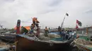 Nelayan Pakistan menyiapkan jaring ikan mereka di atas kapal di pelabuhan di Karachi (3/4). Pembuatan kapal buatan Pakistan menghasilkan ratusan kapal setiap tahun untuk memenuhi permintaan industri perikanan setempat. (AFP Photo/Asif Hassan)