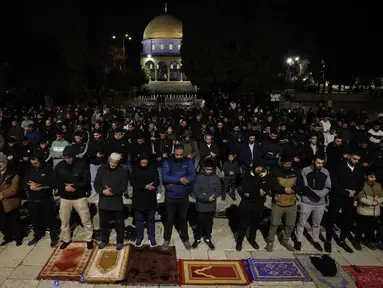 Para jamaah Muslim Palestina melaksanakan salat Tarawih pada malam pertama bulan suci Ramadan di dekat Kubah Batu, kompleks Masjid Al-Aqsa, Kota Tua Yerusalem pada 17 Februari 2026. (AHMAD GHARABLI/AFP)