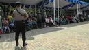 Anggota polisi mengamankan lokasi penukaran uang receh di Monas, Jakarta, Selasa (30/6/2015). Bank Indonesia bekerjasama dengan 14 bank lainnya membuka loket penukaran uang pecahan kecil sejak 17 Juni-15 Juli 2015. (Liputan6.com/Faizal Fanani)