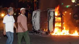 Sejumlah warga melihat mobil terbakar di jalan Diponegoro, Jakarta, Kamis malam (29/3). Aksi menolak kenaikan Bahan Bakar Minyak (BBM) berakhir bentrok. (Antara)