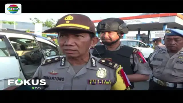 Puluhan personel kepolisian bersenjata lengkap disiagakan di pintu masuk penyebrangan pelabuhan laut Ketapang, Banyuwangi.
