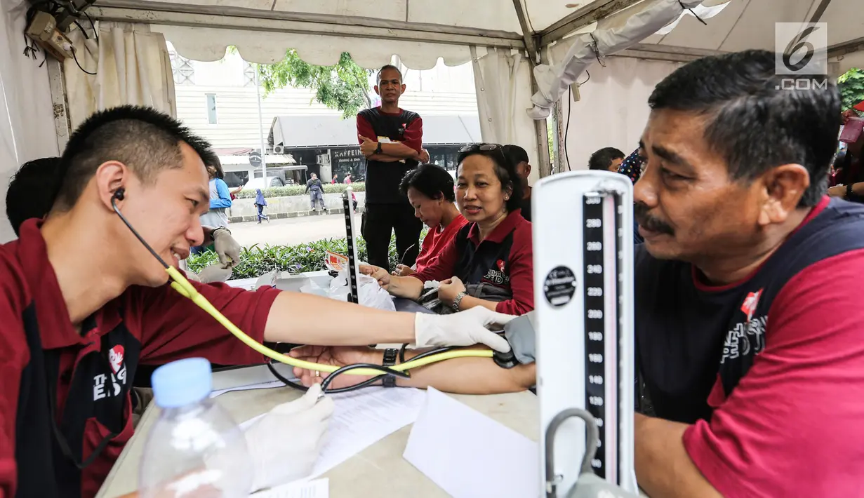Warga memeriksa tensi tekanan darah pada acara Family Day Artha Graha Peduli (AGP) di Pasar Akhir Pekan SCBD, Jakarta, Minggu (25/11). Pengobatan gratis bertujuan membantu menjaga kesehatan warga sekitar. (Liputan6.com/Fery Pradolo)