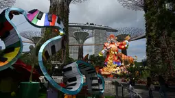 Patung lentera Dewa Keberuntungan (kanan) untuk perayaan Tahun Baru Imlek yang akan datang terlihat di Gardens by the Bay Supertree Grove, Singapura, 18 Januari 2022. (Roslan RAHMAN/AFP)