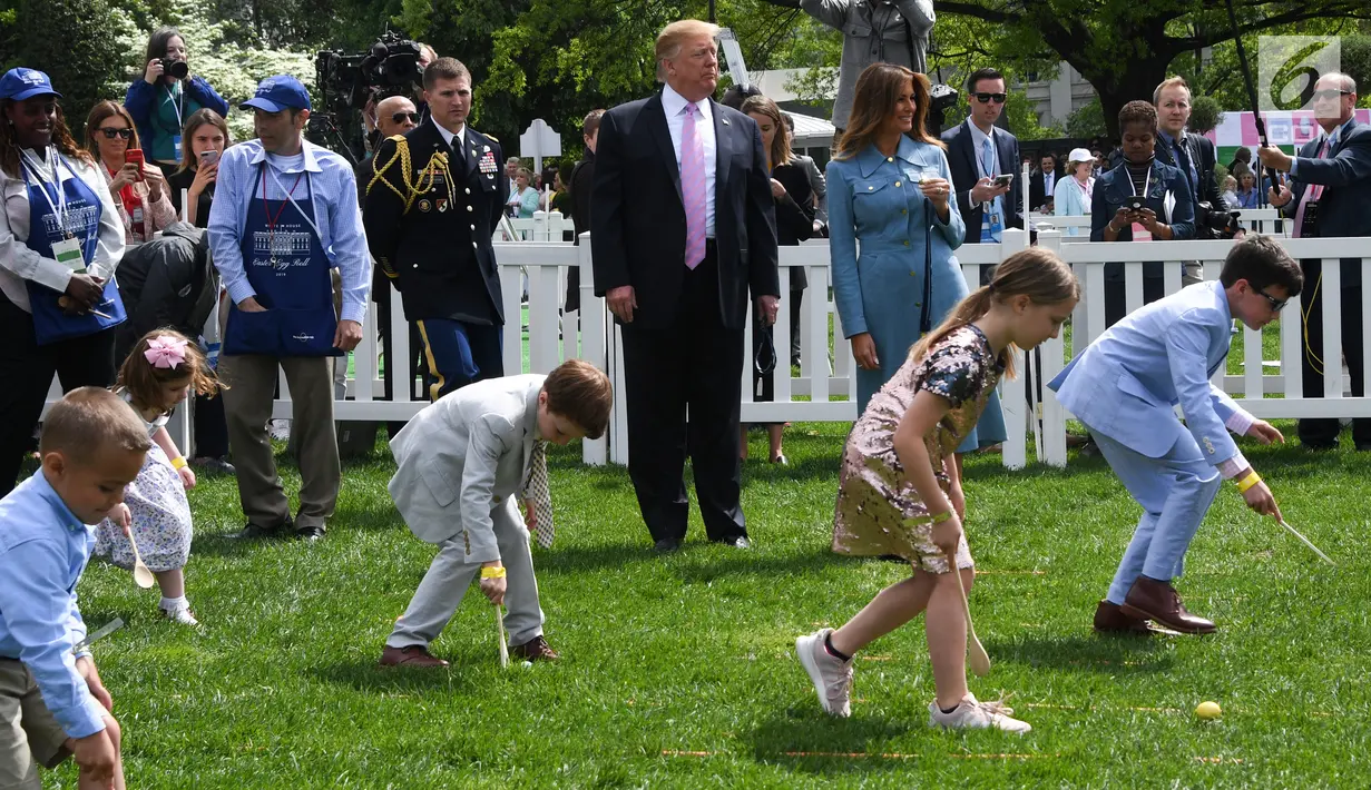 Presiden AS Donald Trump dan Ibu Negara Melania Trump menyaksikan anak-anak menggelindingkan telur paskah di halaman Gedung Putih, Washington, Senin (22/4). Acara tahunan itu merupakan bagian dari rangkaian memperingati Paskah yang rutin diselenggarakan di South Lawn Gedung Putih. (Jim WATSON / AFP)