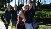 Siswa tampak terguncang setelah terjadi penembakan massal yang mengguncang sekolah menengah atas Marjory Stoneman Douglas di Parkland, Florida, Rabu (14/2). Pelaku penembakan menyerahkan diri tanpa perlawanan kepada polisi. (Michele Eve Sandberg/AFP)