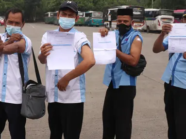 Sejumlah pekerja transportasi memperlihatkan kartu vaksinasi COVID-19 usai divaksin di Terminal Poris Plawad, Cipondoh, Kota Tangerang, Kamis (4/3/2021). Sebanyak 1.000 peserta pekerja transportasi mulai dari sopir angkot, bus, taksi dan ojek yang divaksinasi Covid-19. (Liputan6.com/Angga Yuniar)