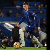 Pemain Chelsea, Cole Palmer (kanan) menggiring bola melewati wasit Stuart Attwell yang sedang terjatuh dalam laga lanjutan Liga Inggris 2024/2025 melawan West Ham di Stamford Bridge, London, Inggris, Selasa (04/02/2025) WIB. (AFP/Adrian Dennis)