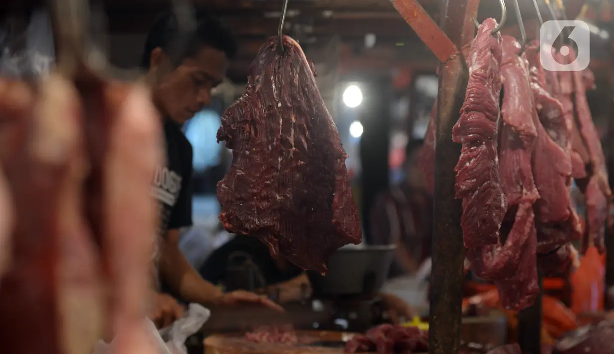 Pedagang memotong daging sapi saat melayani pembeli di Pasar Perumnas, Jakarta, Selasa (19/1/2021). Pedagang daging sapi akan mogok jualan sebagai bentuk protes kepada pemerintah karena tingginya harga daging sapi di pasar sejak awal tahun. (merdeka.com/Imam Buhori)