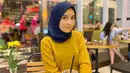 Saat hangout ke kafe bareng bestie, Amira lebih memilih bergaya simpel. Seperti pada potretnya kali ini. Istri pedangdut yang kini memiliki pengikut 33ribu lebih di Instagram itu memakai kaus berwarna gold, yang dipadukan dengan hijab navy. Polesan makeup-nya pun terlihat begitu natural. (Liputan6.com/IG/@amira_krmn)