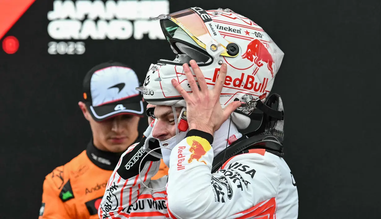 Pembalap Red Bull Racing asal Belanda, Max Verstappen (kanan) melepas helmnya setelah kemenangannya pada Fomula 1 Grand Prix Jepang di sirkuit Suzuka, prefektur Mie, Jepang pada 6 April 2025. (Toshifumi KITAMURA/AFP)