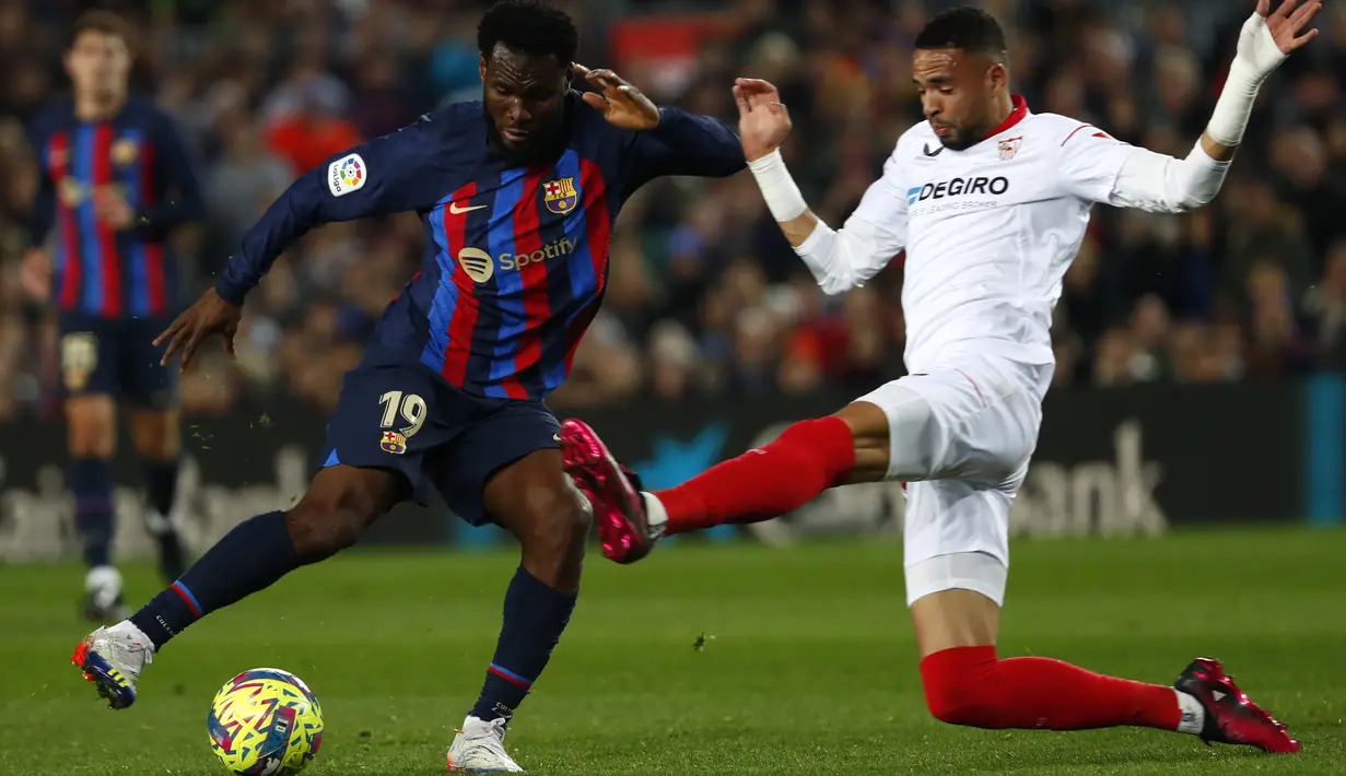 Gelandang Barcelona Franck Kessie berebut bola dengan penyerang Sevilla Youssef En-Nesyri pada jornada ke-20 La Liga 2022/2023 di Camp Nou, Senin (6/2/2023) dini hari. Sementara itu Sevilla kian terpuruk menempati peringkat 16 dengan 21 poin, hanya dua poin di atas Cadiz di zona degradasi. (AP Photo/Joan Monfort)
