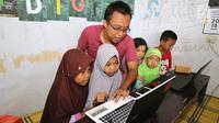 Penggagas Kebumen Desa Digital, Wahyu Yoga Pratama memberikan pelatihan internet kepada anak-anak, di Desa Tambakprogaten, Kabupaten Kebumen, Jawa Tengah, Minggu (6/5). (Liputan6.com/Fery Pradolo)