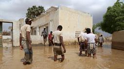 Sejumlah Warga melintasi banjir setelah hujan lebat di sebuah desa di provinsi Laut Merah Yaman, Houdieda, Jumat,  15 April 2016. (REUTERS/Abdul Jabbar Zeyad)