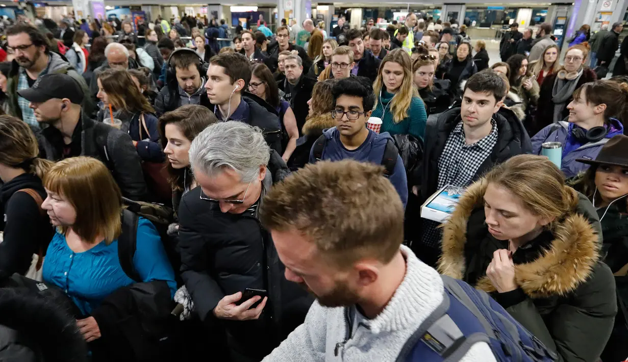Penumpang Amtrak menunggu untuk naik eskalator menuju platform kereta api di Penn Station New York, Rabu (21/11). Masyarakat Amerika mulai bergegas pulang ke kampung halamannya alias mudik untuk merayakan Thanksgiving Day. (AP/Mark Lennihan)