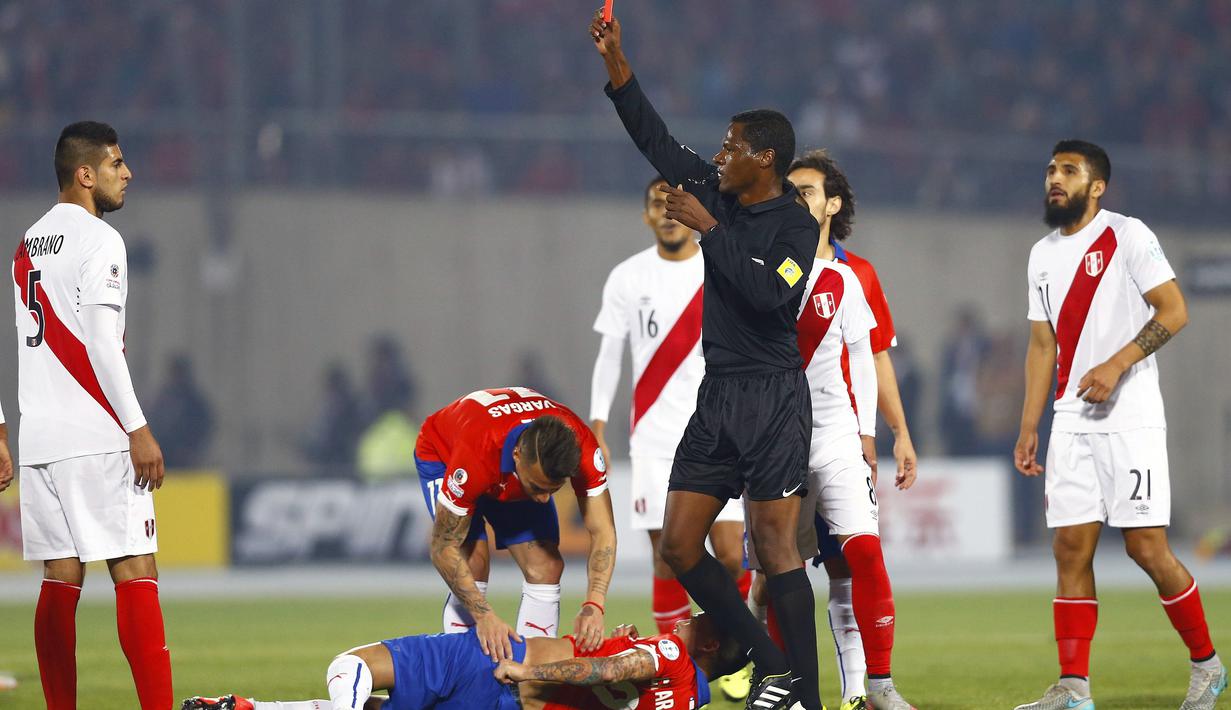 Wasit Jose Argote memberikan kartu merah kepada pemain Peru, Carlos Augusto Zambrano (kiri) setelah menendang punggung pemain Cile, Charles Aranguiz. (EPA/Javier Valdes)