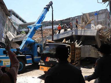 Tim penyelamat membersihkan puing-puing di lokasi runtuhnya bangunan yang sedang dibangun di sebuah pondok pesantren di Sidoarjo, Jawa Timur, Kamis 2 Oktober 2025. (AP Photo/Trisnadi)