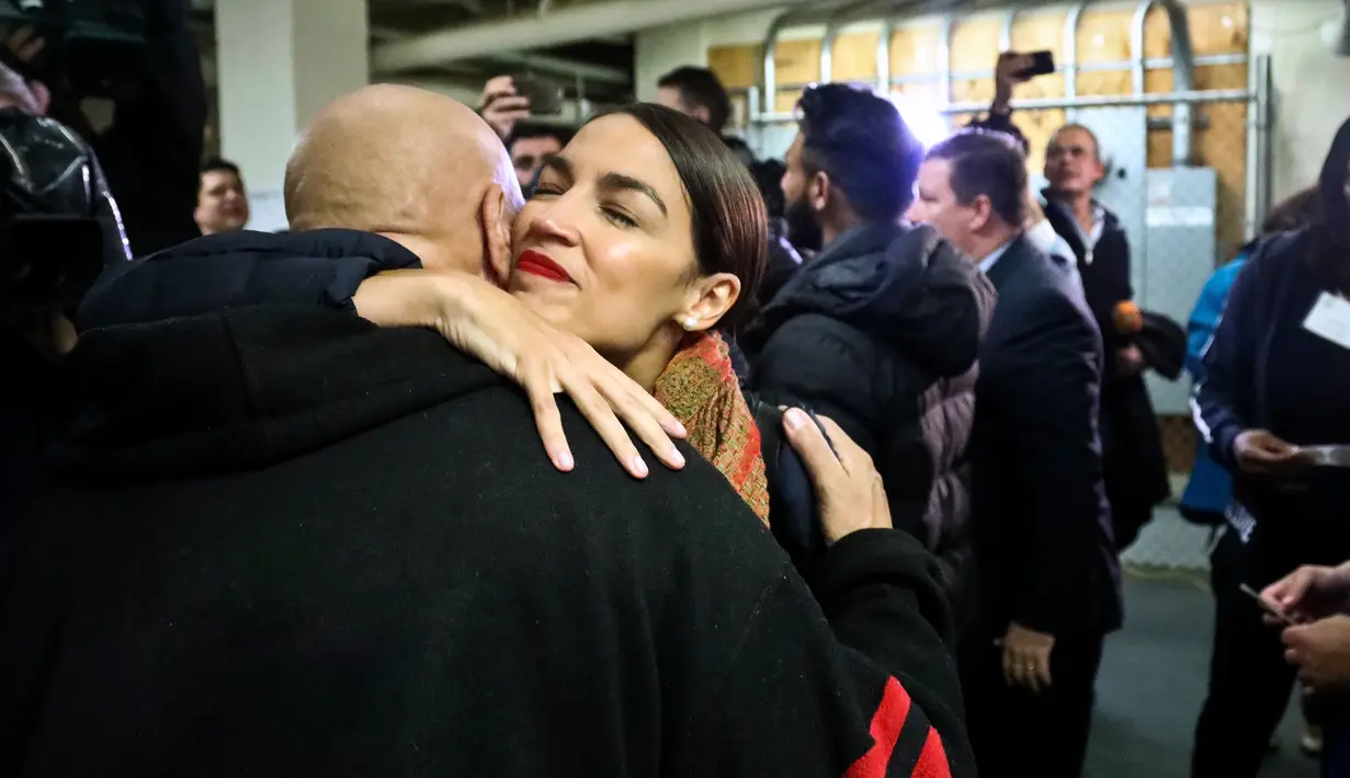 Calon anggota kongres AS Alexandria Ocasio-Cortez  merangkul pendukungnya usai pemungutan suara di komunitas Parkchester, Bronx, New York, Selasa (6/11). Kader Partai Demokrat ini meraup 78,9 persen suara saat pemungutan suara. (AP Photo/Bebeto Matthews)