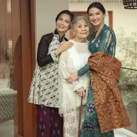 Sang nenek tampil dengan atasan putih lengan panjang transparan dihiasi detail bordiran. Elegan dengan hair clipnya. [@kain.menggahagung]