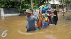 Warga membantu mendorong gerobak penjual prabotan di komplek Polri jalan Pondok Karya, Mampang, Jakarta, Kamis (21/4). Banjir setinggi 120cm disebabkan meluapnya Kali Mampang. (Liputan6.com/Gempur M Surya)