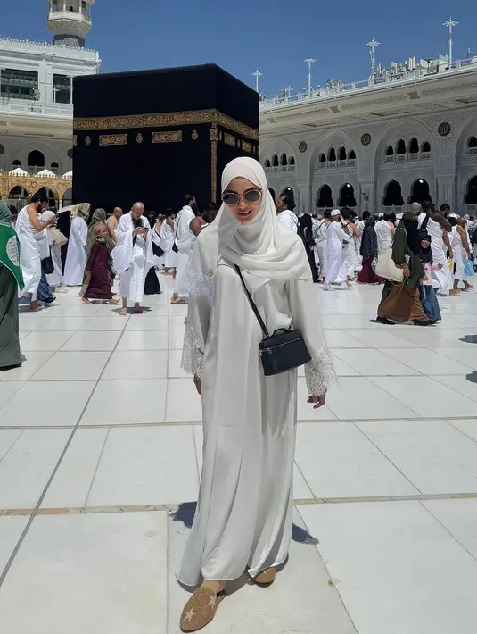 Berfoto depan Khabah di siang hari, Ririn Ekawati padukan kaftan lace dengan hijab putih. Lengkapi tampilan, ia kenakan sling bag hitam dari Loro Piana dan mules sandal gold [@ririnekawati]
