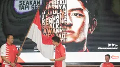 Rio Haryanto mencium bendera merah putih yang dipegang Menpora Imam Nahrawi sesaat setelah resmi diumumkan sebagai pebalap F1 bersama tim Manor Racing di kantor pusat Pertamina, Jakarta, Kamis (18/2/2016). (Bola.com/Vitalis Yogi Trisna)