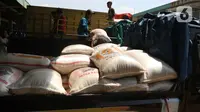 Buruh memenidahkan karung beras di pasar induk beras Cipinang, Jakarta, Sabtu (16/5/2020).  mengantisipasi penyebaran Covid-19 sejumlah kuli dan buruh di Pasar Induk beras Cipinang diberi obat herbal mentah untuk meredakan panas. (Liputan6.com/Herman Zakharia)