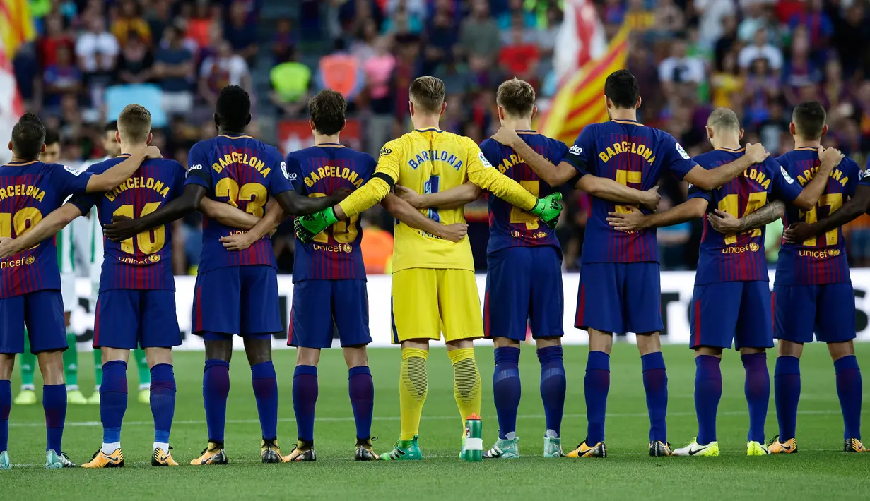Pemain Barcelona mengheningkan cipta sebelum melakoni laga pekan pertama Liga Spanyol melawan Real Betis di Stadion Camp Nou, Minggu (20/8). Aksi tersebut sebagai bentuk duka cita atas serangan teror di pusat Kota Barcelona. (AP Photo/Manu Fernandez)