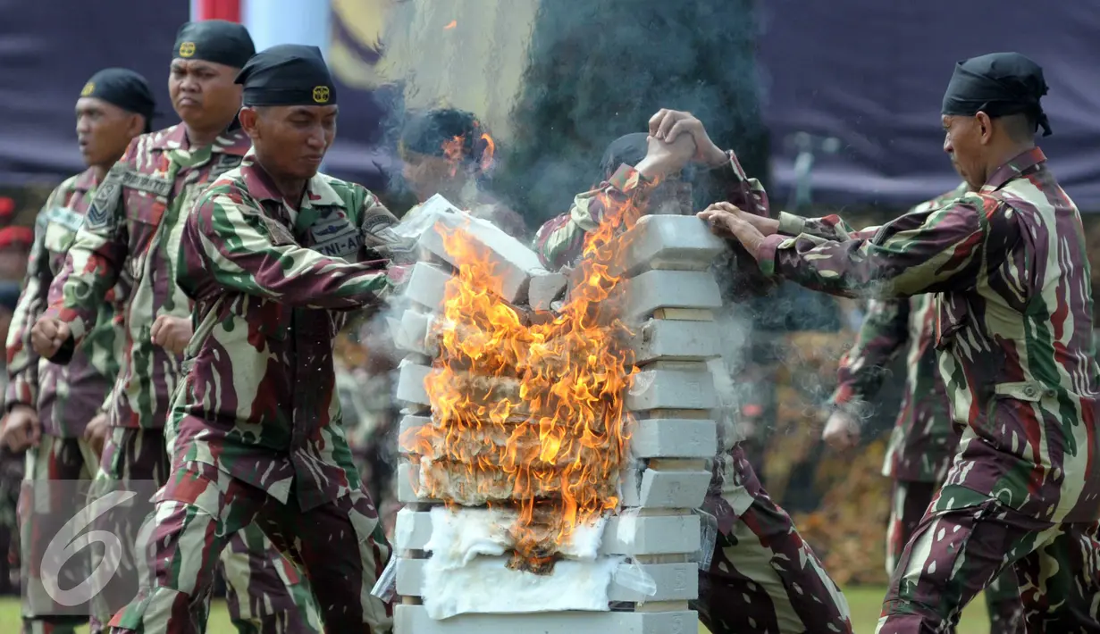 Aksi prajurit menghancurkan batu saat HUT Kopassus ke-64 di Makopassus, Cijantung, Jakarta, Sabtu (16/4). HUT mengangkat Tema Loyalitas, Moralitas dan Integritas demi mewujudkan Prajurit Hebat Profesional dan Dicintai Rakyat. (Liputan6.com/Helmi Afandi)