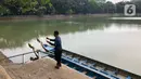 Seorang pria membawa alat pancing saat di Perkampungan Budaya Betawi Setu Babakan, Jakarta, Senin (22/6/2020). Danau buatan seluas 30 hektare tersebut kembali dibuka untuk umum setelah sebelumnya ditutup untuk mencegah penyebaran virus corona COVID-19. (Liputan6.com/Immanuel Antonius)