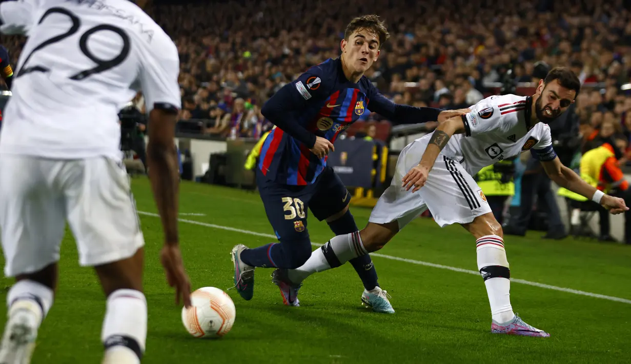 Gelandang Barcelona Gavi berebut bola dengan pemain Manchester United (MU) Bruno Fernandes dan Aaron Wan-Bissaka pada leg pertama play-off babak gugur Liga Europa 2022/2023 di Camp Nou, Jumat (17/2/2023) WIB. Hasil ini membuat pertemuan di leg kedua yang berlangsung di Old Trafford akan sangat menentukan. (AP Photo/Joan Monfort)