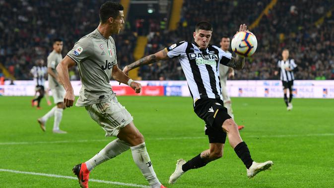 Penyerang Juventus, Cristiano Ronaldo berusaha mengumpan bola dari kawalan pemain Udinese Rodrigo De Paul pada lanjutan Liga Serie A Italia di Stadion Dacia Arena (6/10). Juventus menang 2-0 atas Udinese. (AFP Photo/Miguel Medina)