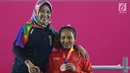 Atlet Para Powerlifting Indonesia, Ni Nengah Widiasih (kanan) saat prosesi medali Womens Up to 41.00kg Asian Para Games 2018 di Jakarta, Minggu (7/10). Ni Nengah Widiasih berhasil melakukan total angkatan 97 kg. (Liputan6.com/Helmi Fithriansyah)