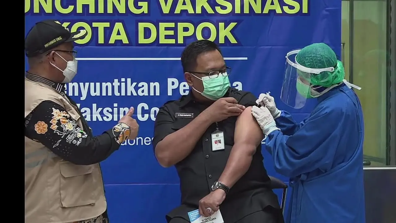 Wakil Wali Kota Depok Pradi Supriatna (tengah) menjadi orang pertama di Depok yang mendapat vaksin Covid-19. Vaksinasi dilakukan di Rumah Sakit Universitas Indonesia bersama 9 orang pejabat Depok lainnya.