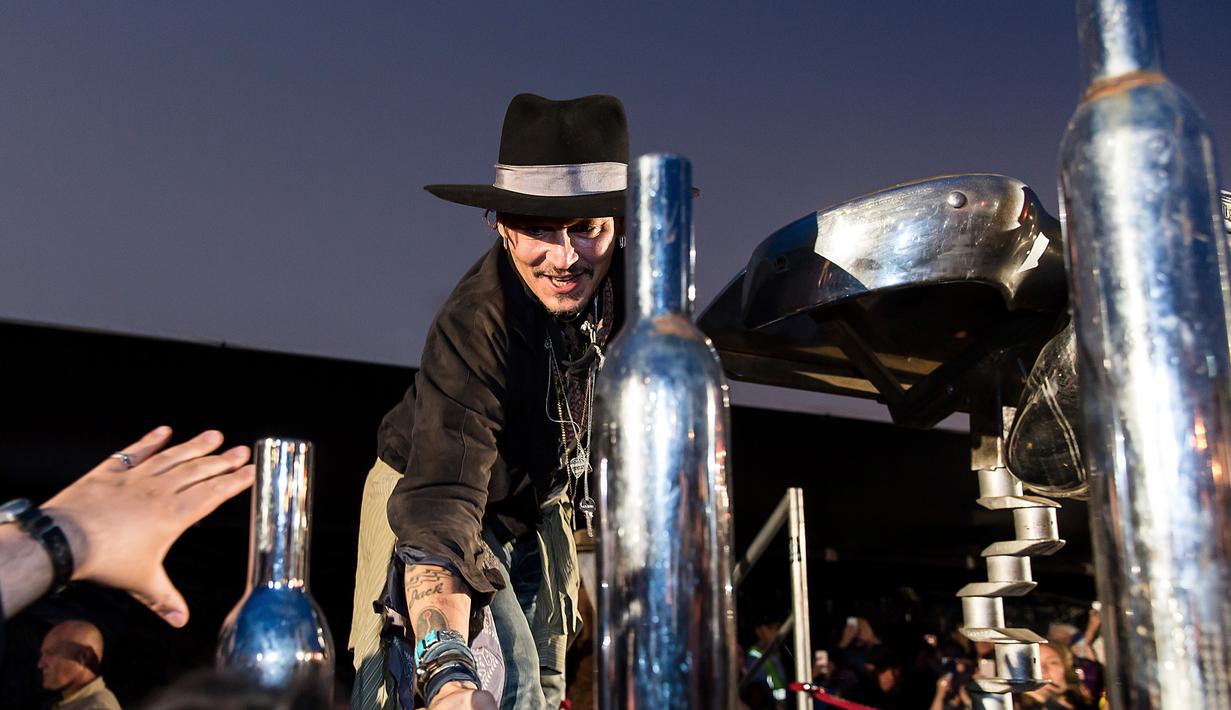 Johnny Depp menyapa penggemarnya sebelum mempresentasikan film terbarunya berjudul The Libertine, di Cinemageddon, Worthy Farm, Somerset selama Festival Glastonbury di Inggris, (22/6). (Photo by Grant Pollard/Invision/AP)