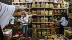 Pedagang kue kering melayani pembeli di Pasar Mayestik, Jakarta, Senin (3/5/2021). Omzet penjualan kue kering menjelang Lebaran tahun ini mengalami peningkatan hingga 70 persen dari tahun sebelumnya yang mengalami penurunan hingga 70 persen. (Liputan6.com/Johan Tallo)