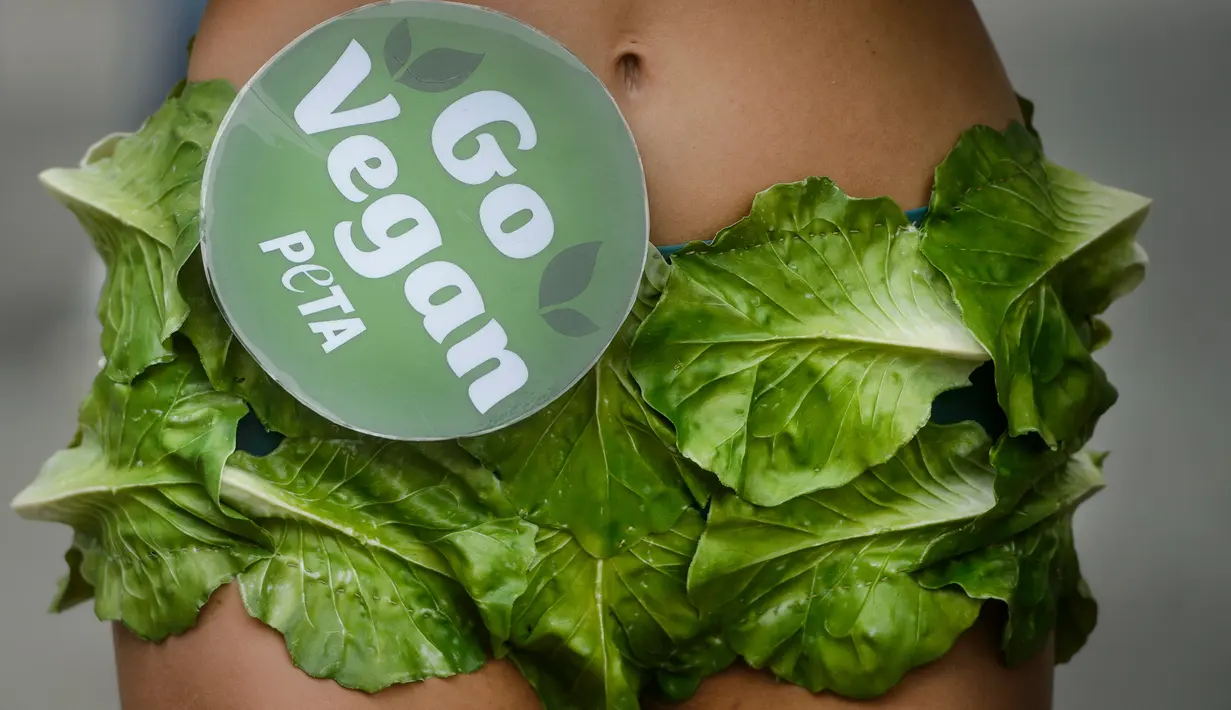 Salah satu "Lettuce Ladies" aktivis PETA berdiri dalam sebuah acara yang mempromosikan gaya hidup vegan di pusat kota Bucharest, Rumania,( 14/8). Kampanye hidup vegan ini akan berlanjut ke negara AS, Rusia da Turki. (AP Photo/Andreea Alexandru)