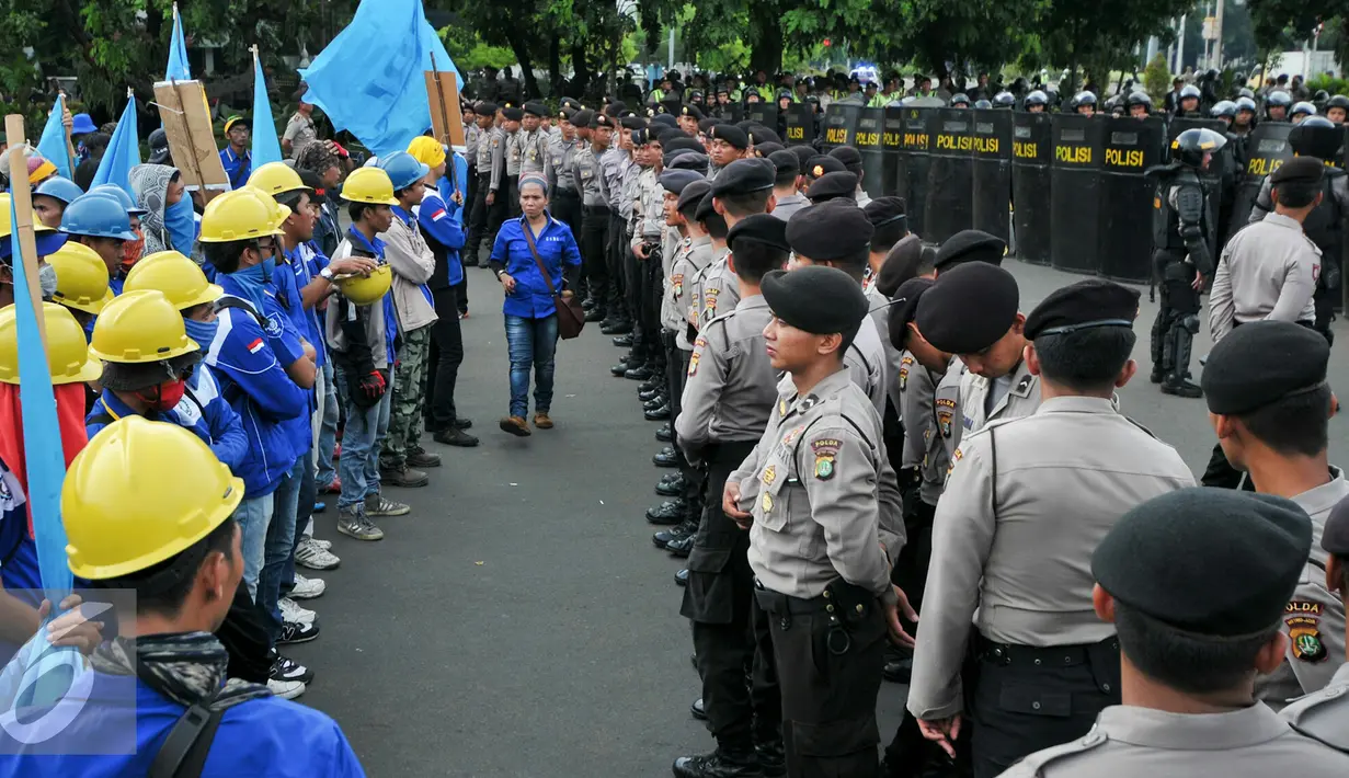 Petugas kepolisian saat menghadang ribuan buruh saat mengelar aksi di Jalan Medan Merdeka, Jakarta, Kamis (10/12). Buruh kembali melakukan aksi demonstrasi menolak PP 78 tahun 2015. (Liputan6.com/Yoppy Renato)