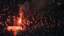 Para supporter Liverpool menyalakan suar saat klubnya bertandang ke markas MU pada laga leg kedua babak 16 Liga Europa di Stadion Old Trafford, Inggris, Jumat (18/3/2016) dini hari WIB. (AFP/Oli Scarff)