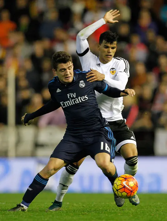 Gelandang Real Madrid, Mateo Kovacic (kiri) berusaha mengontrol bola dari kawalan gelandang Valencia, Salvador Danilo pada lanjutan liga Spanyol di stadion Mestalla, (3/1/2015). Real Madrid bermain imbang dengan Valencia dengan skor 2-2. (AFP/JOSE JORDAN)